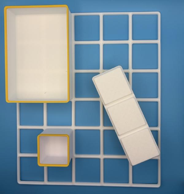 Gridfinity baseplate with three simple plain white containers with yellow edges.